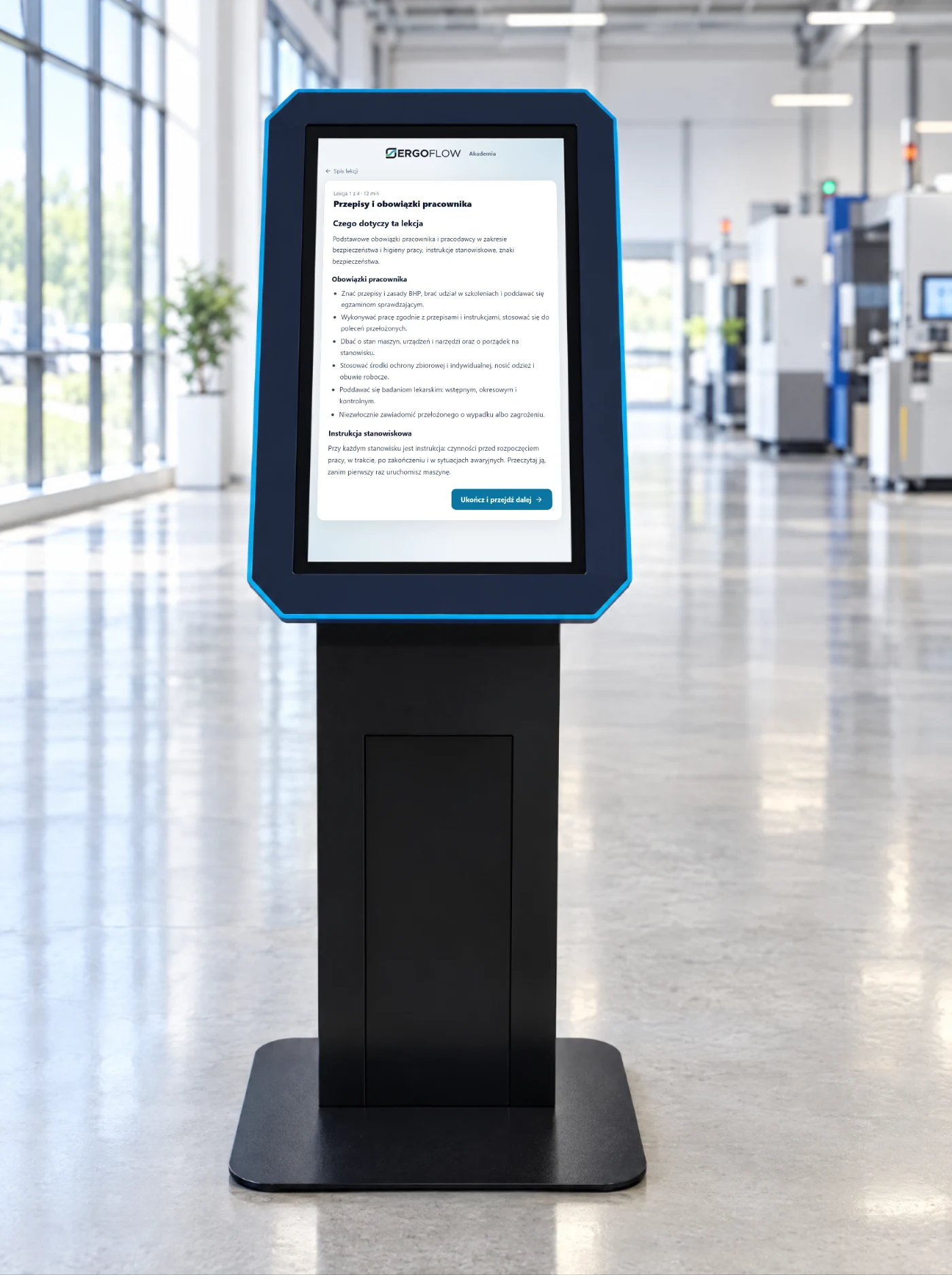 Kiosk z ekranem dotykowym w hali, na ekranie lekcja szkolenia BHP.